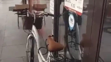 Bisikletini banka kapısına kilitledi