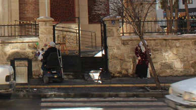 Cami bahçesinde cemaat, kapısında dilenciler